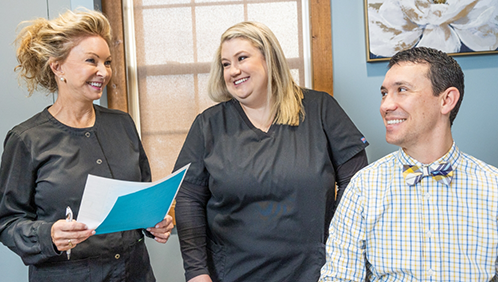 Doctor Parry smiling with two team members