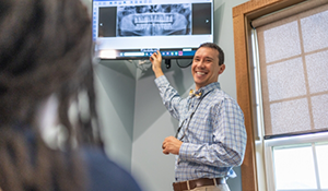 Doctor Parry showing a patient an x ray of their teeth