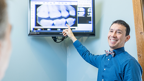 Doctor Parry showing a patient x rays of their teeth
