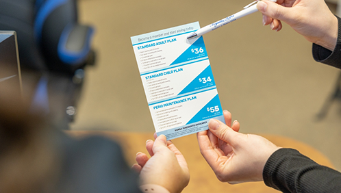 Dental team member showing a pamphlet to a patient