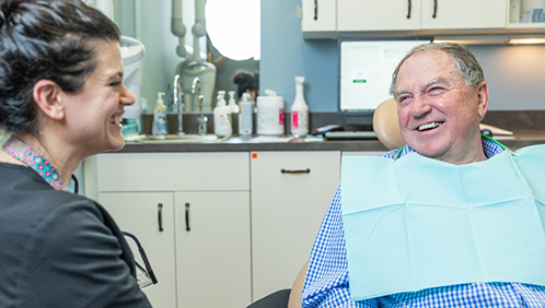 Man in the dental chair smiling at a team member
