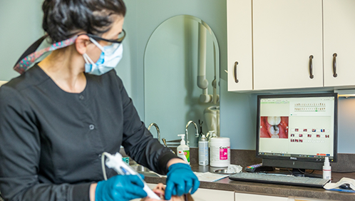 Dental team member examining a patient's mouth