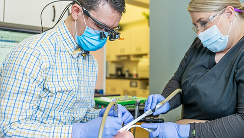 Doctor Parry and a dental assistant treating a patient