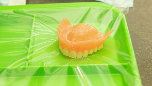 Full denture resting on a plastic tray