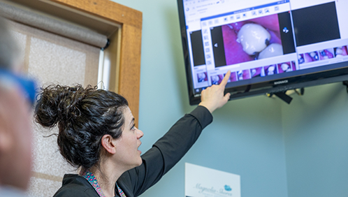 Dental team member showing a patient photos of their teeth