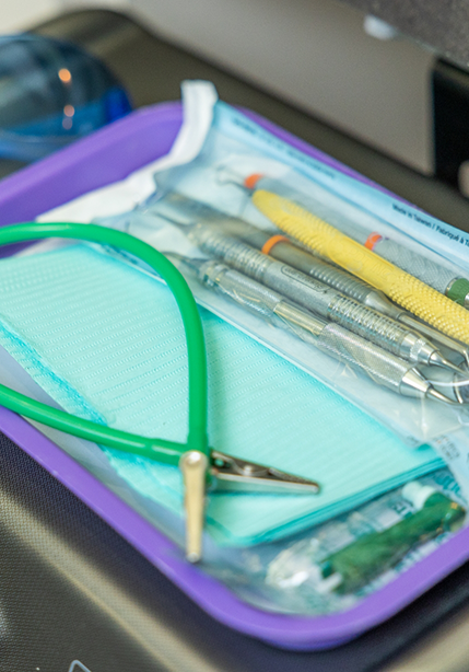 Tray of dental tools beside a treatment chair