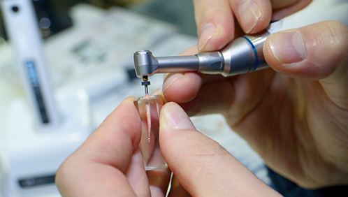 Dental instrument performing root canal treatment on a model of a tooth