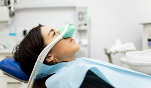 Dental patient with a nitrous oxide mask over her nose