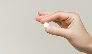 Person holding a white pill