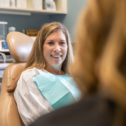 Smiling woman receiving dental treatment