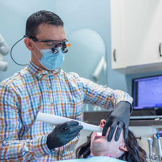 Doctor Parry using advanced technology to treat dental patient