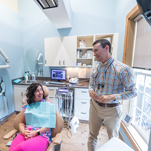 Man in dental chair shaking dentist's hand