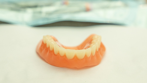 Denture on a flat white surface