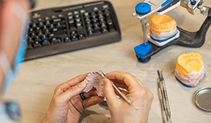 Ceramist adjusting a denture