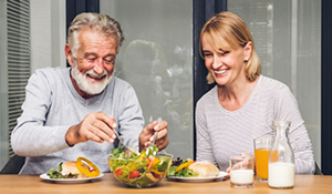 Older man and woman eating a salad
