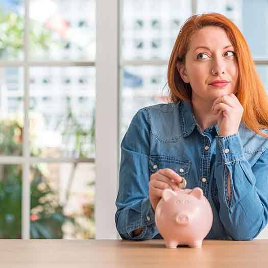 Woman putting a coin in a piggy bank